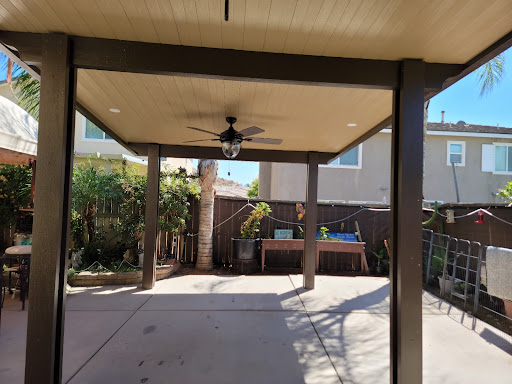 A bright and inviting backyard patio with a ceiling fan, perfect for relaxation.