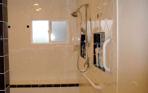 Modern bathroom shower with tiled walls and a grab bar.