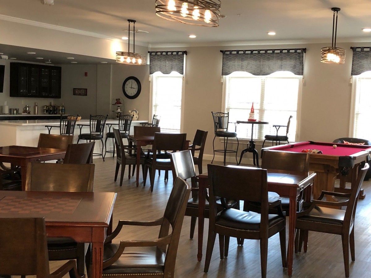 A cozy dining and recreational space with tables, chairs, and a pool table.