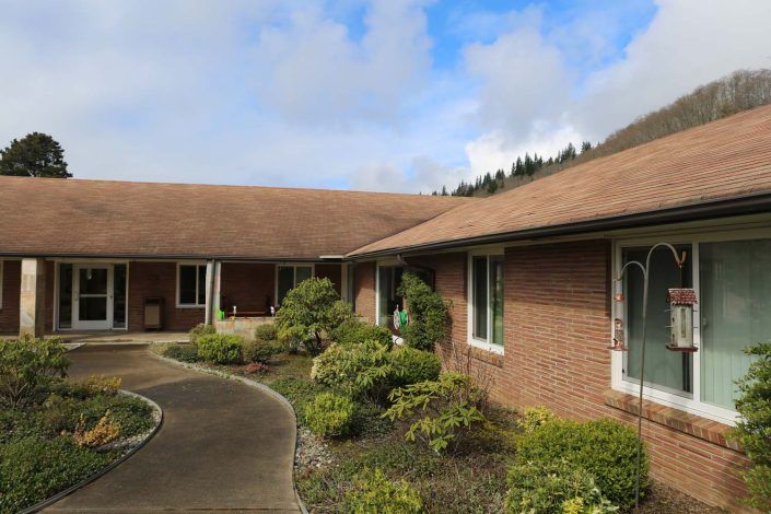 A view of a brick residential house with a landscaped garden and pathway.
