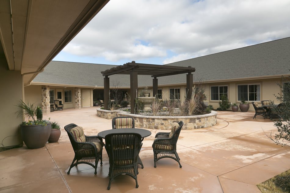 A serene courtyard with outdoor seating and a central pergola structure.