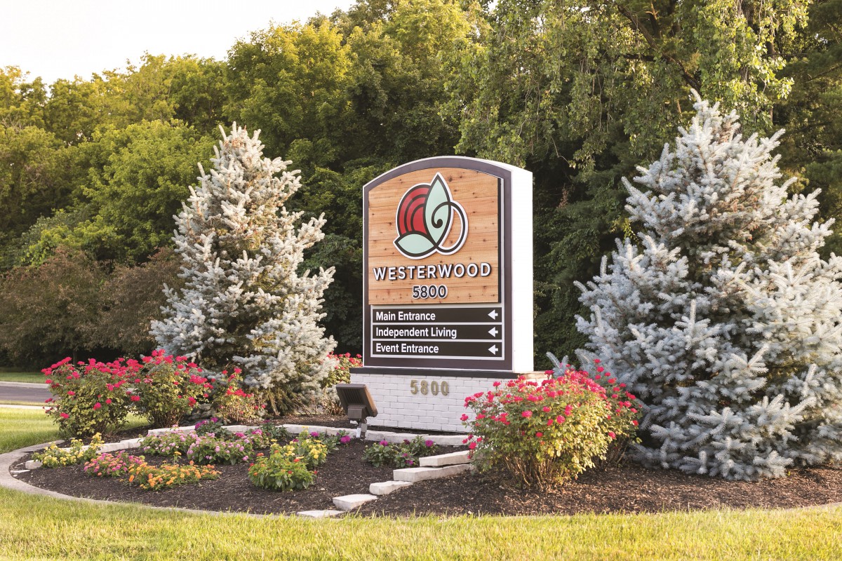 Entrance sign to Phillips Park surrounded by landscaped greenery and flowers.