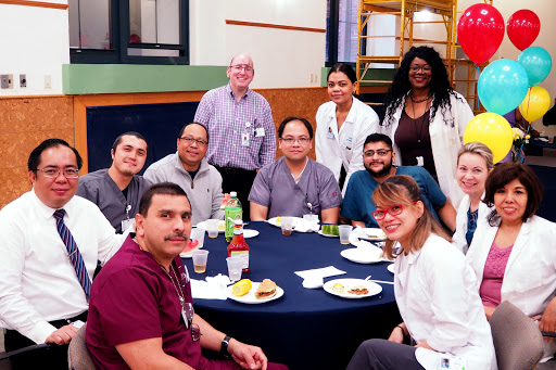 A group of healthcare professionals enjoying a meal together in their breakroom.