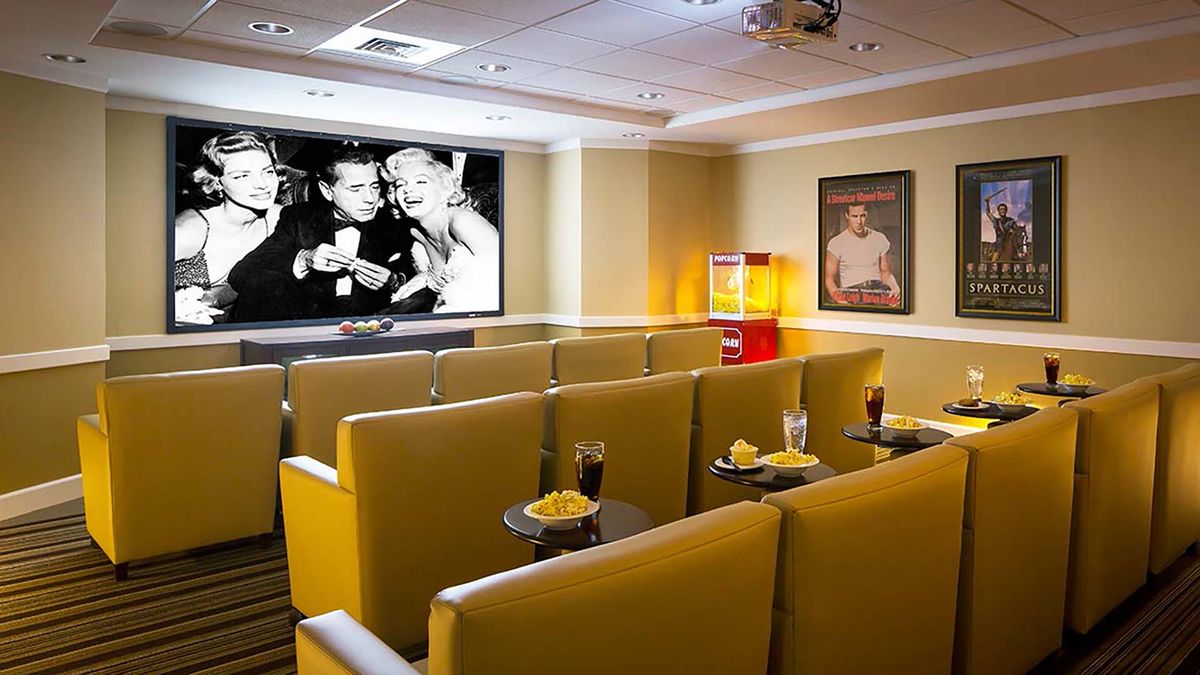 A cozy home theater setup with comfortable yellow seats and a classic movie playing on the screen.