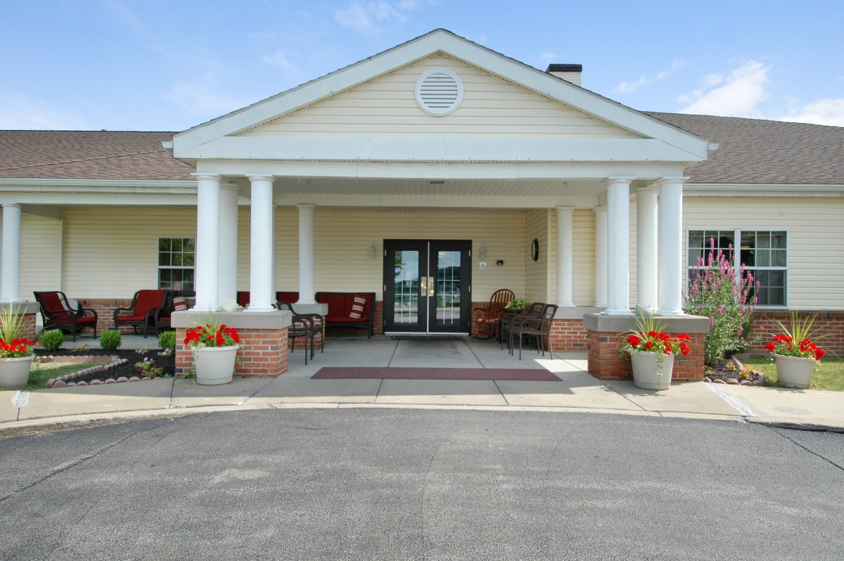 A building entrance with columns and potted flowers.