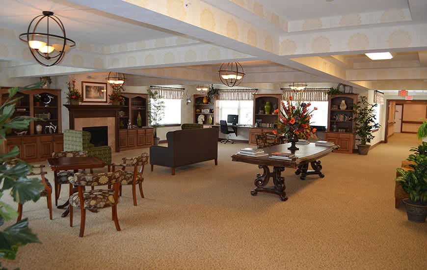 A spacious living room with comfortable seating, a central fireplace, and elegant decor.
