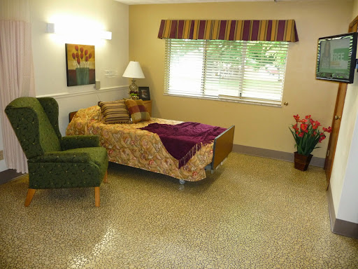 A cozy and well-lit interior space featuring a bed, a green chair, and decorative elements.