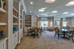 A cozy reading room with bookshelves, elegant seating, and ample natural light.