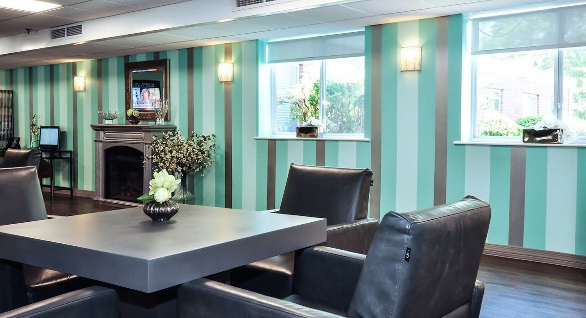 A modern seating area with striped wallpaper and stylish furniture.