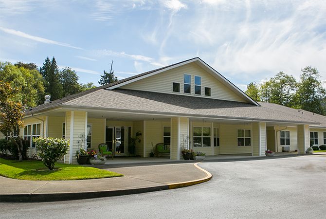 A one-story building with a large entrance and surrounding greenery.