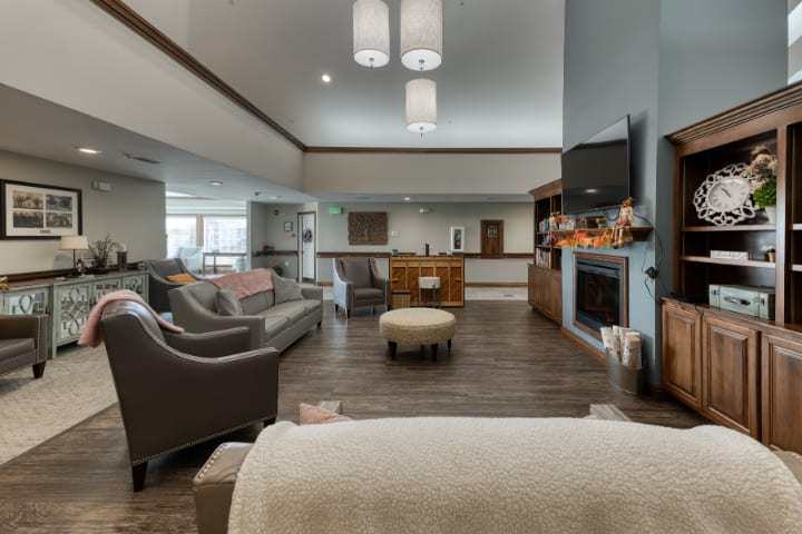 A cozy and spacious living room with modern furniture, a fireplace, and a mounted television.