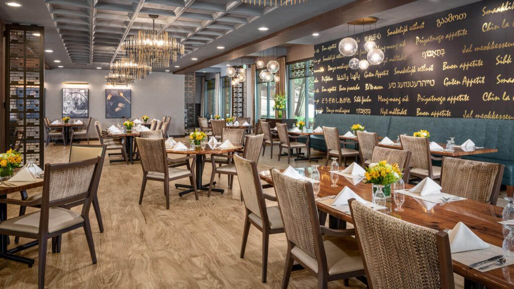 A beautifully decorated restaurant dining area with neatly arranged tables and elegant chandeliers.