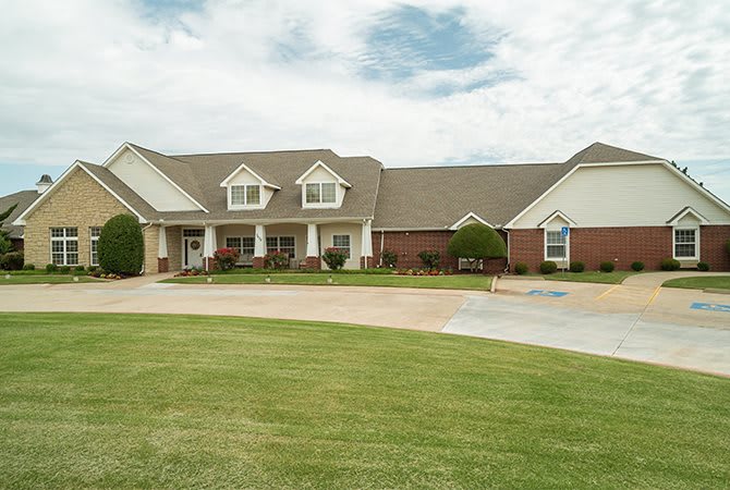 A large suburban house with a well-maintained lawn and driveway.