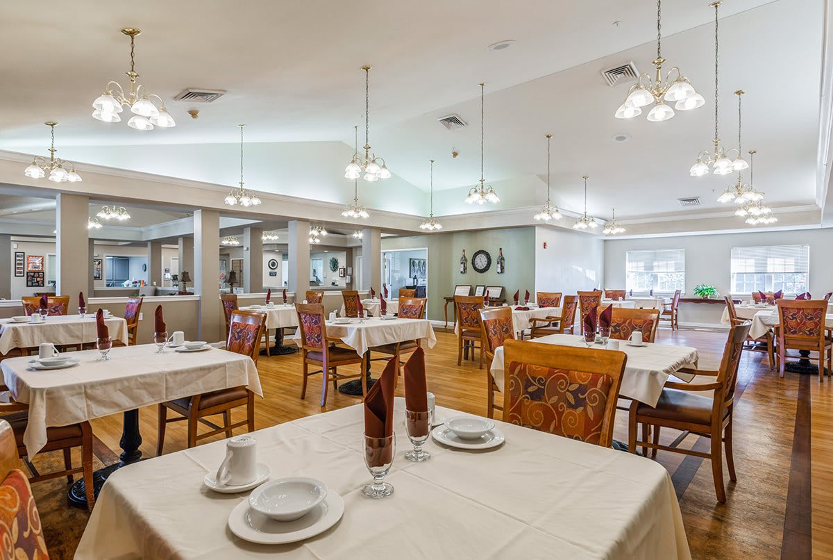 A spacious restaurant dining room with elegantly set tables and comfortable seating.