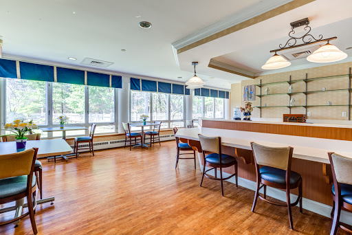 A spacious lounge area featuring a bar and comfortable seating with ample natural light.