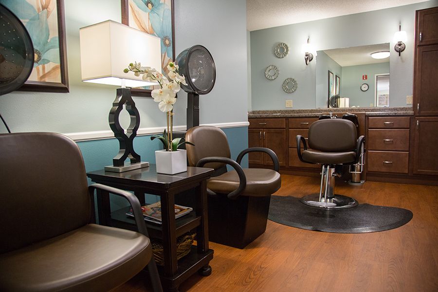 A cozy salon interior with seating and hair styling stations.