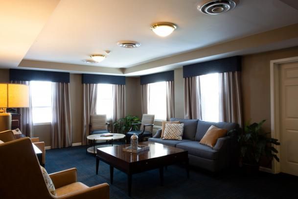 A cozy living room with a sofa, coffee table, and elegant curtains.