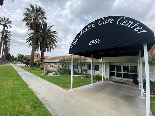 Exterior view of a health care center featuring palm trees and a welcoming entrance.