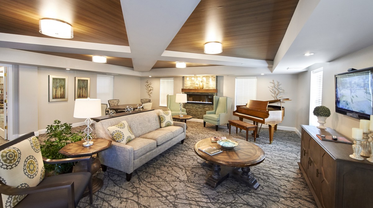 A well-furnished living room featuring a sofa, coffee table, and a grand piano.