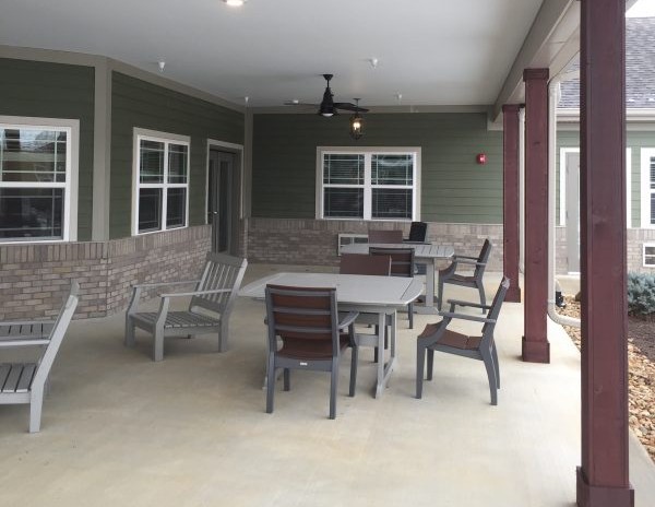 A covered patio area with outdoor furniture including a table and chairs.