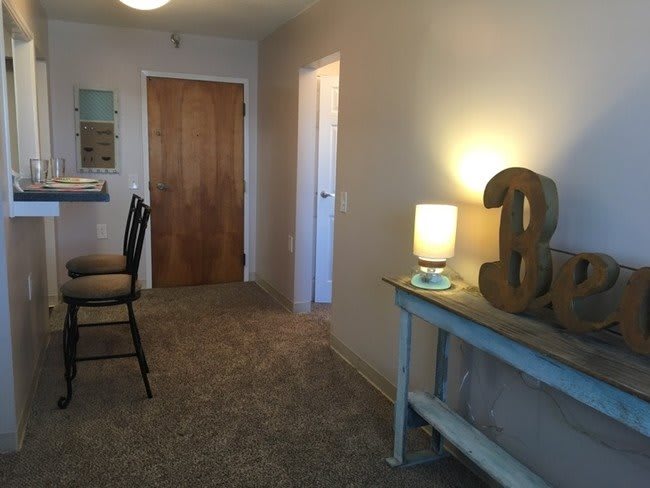 A cozy hallway with a small table, lamp, and decor.