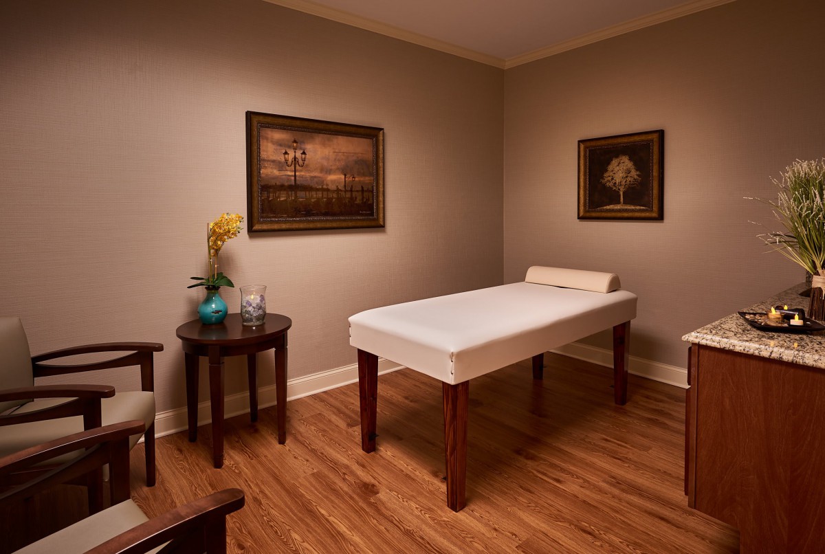 A calming massage room with a therapy bed and soothing decor.