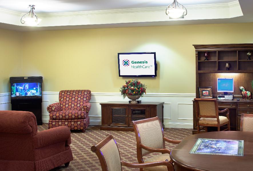 A cozy living room with comfortable furniture, a television mounted on the wall, and decorative elements.