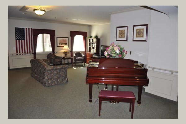 A spacious living room featuring a grand piano, sofa, and elegant decor.