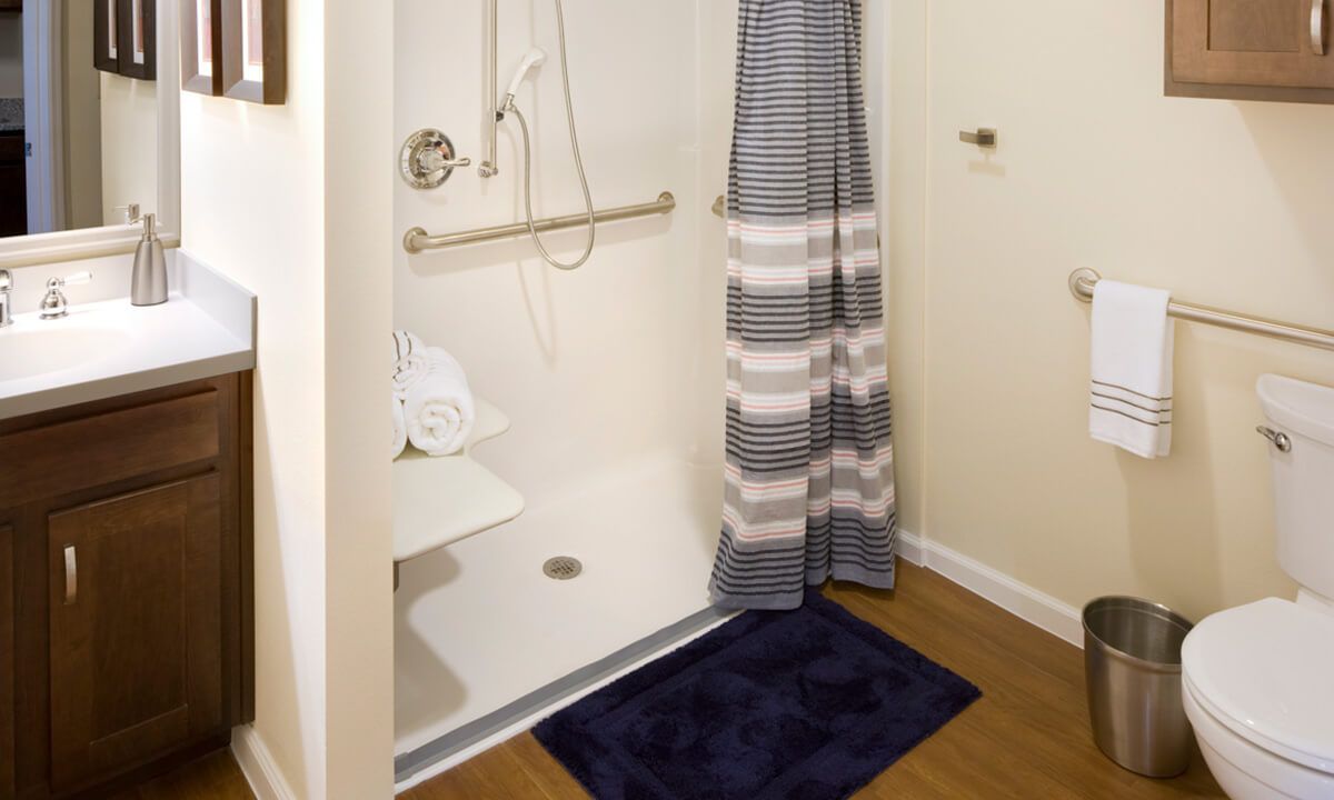 Accessible shower with a grab bar and striped curtain.
