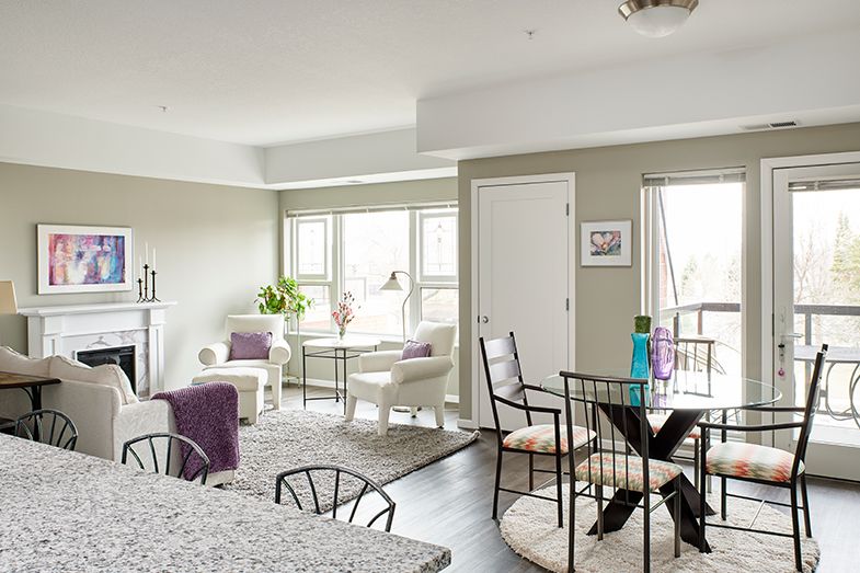 A modern living and dining area with natural lighting, featuring stylish furniture and a contemporary design.