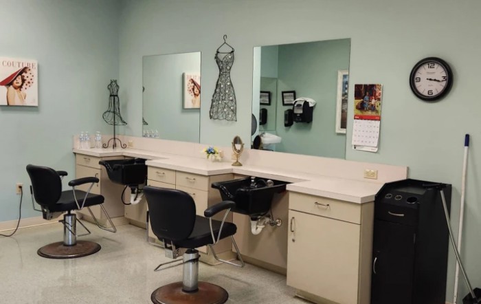 A stylish hair salon featuring mirrors, chairs, and sinks lined up against a wall.