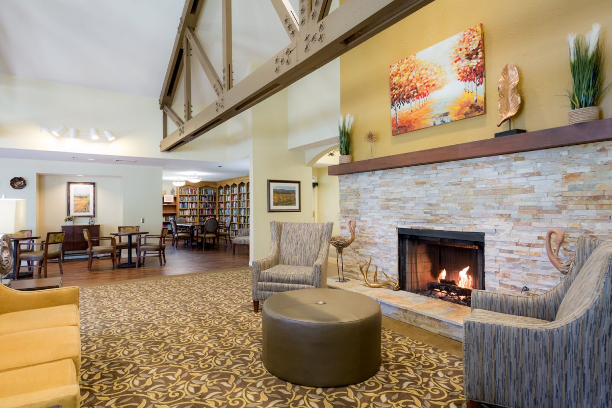 A cozy living room with a fireplace, comfortable seating, and warm decor.