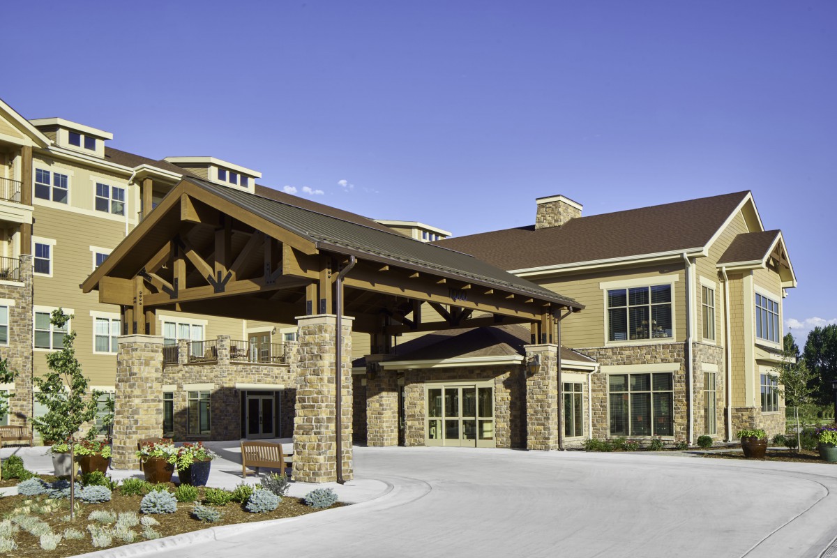 A modern building entrance with stone and wood architectural elements.