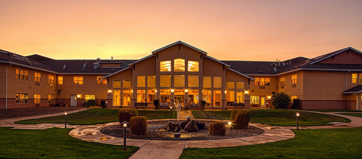 A scenic view of a well-lit building at sunset.