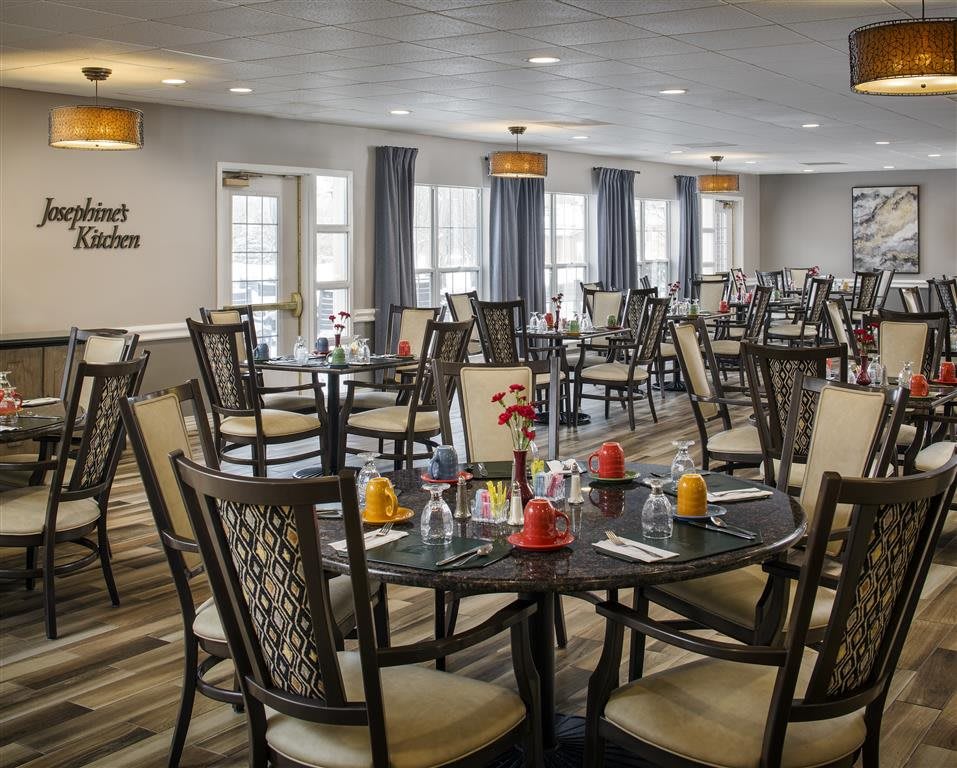 An empty dining room with neatly arranged tables and chairs, ready for guests.