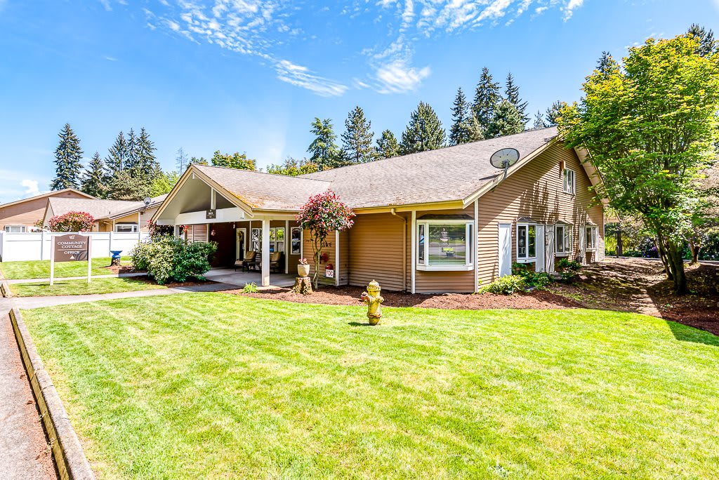 A charming suburban house with a well-maintained lawn on a sunny day.