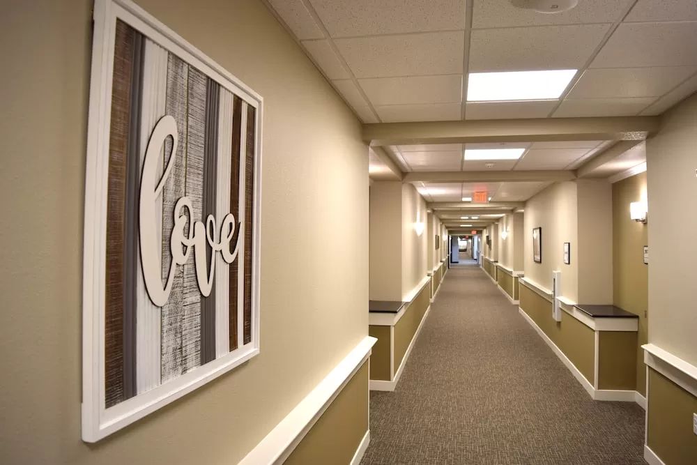 A long hallway with a framed artwork displaying the word 'love' on the wall.