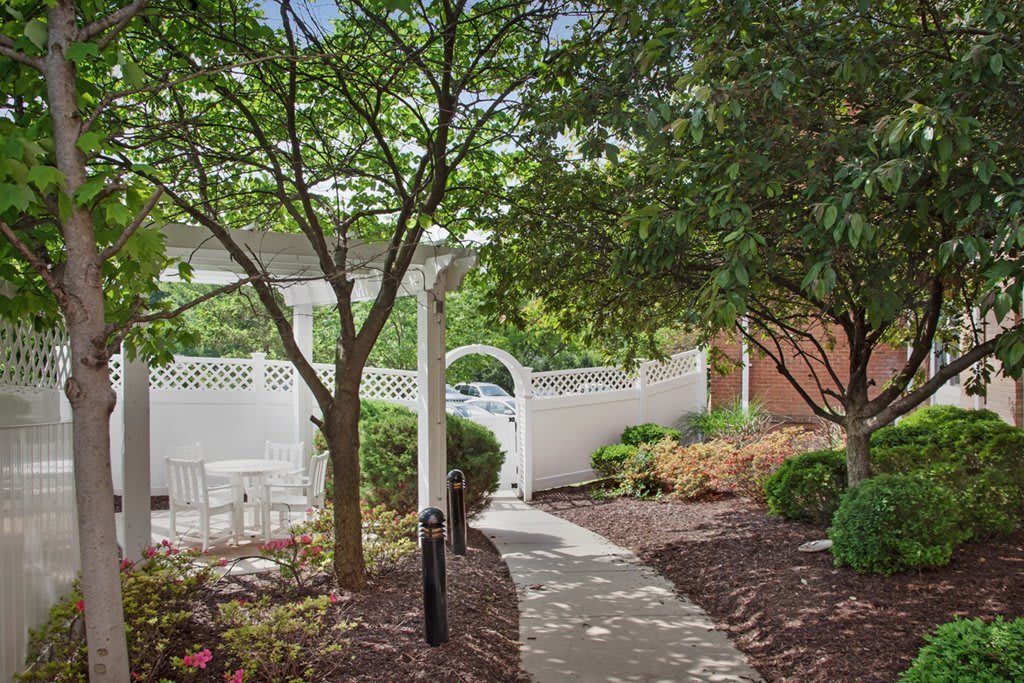 A serene garden pathway with an archway and lush greenery.