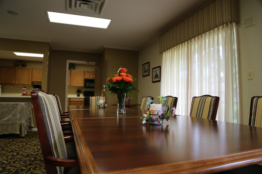 A spacious and well-lit conference room set up for meetings, featuring a long wooden table and elegant decor.