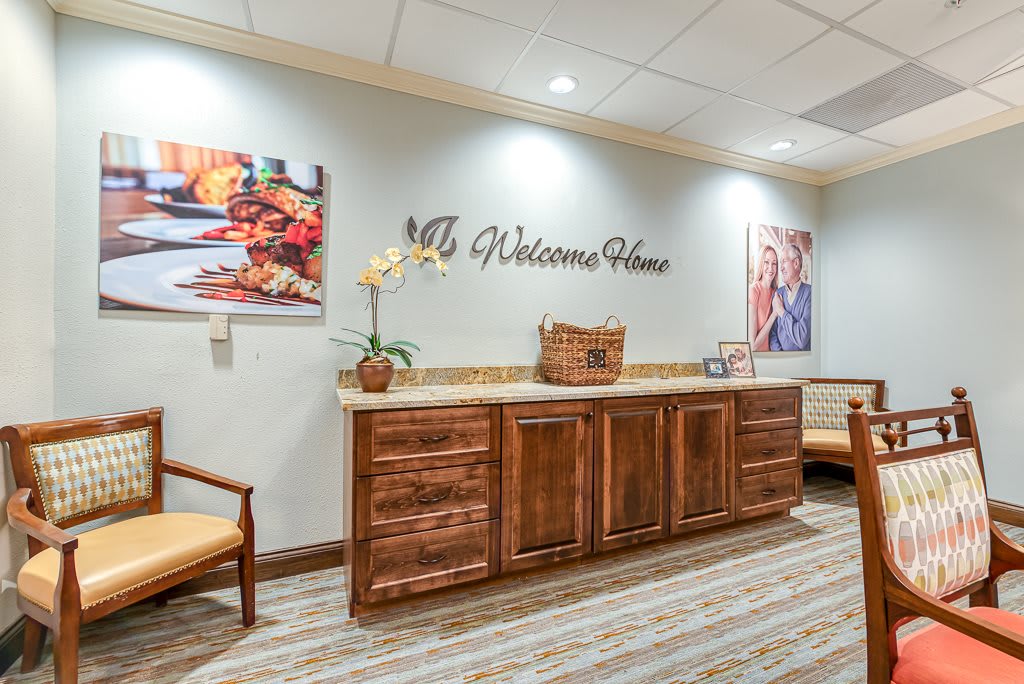 A welcoming reception area featuring a wooden cabinet, comfortable seating, and decorative wall art.