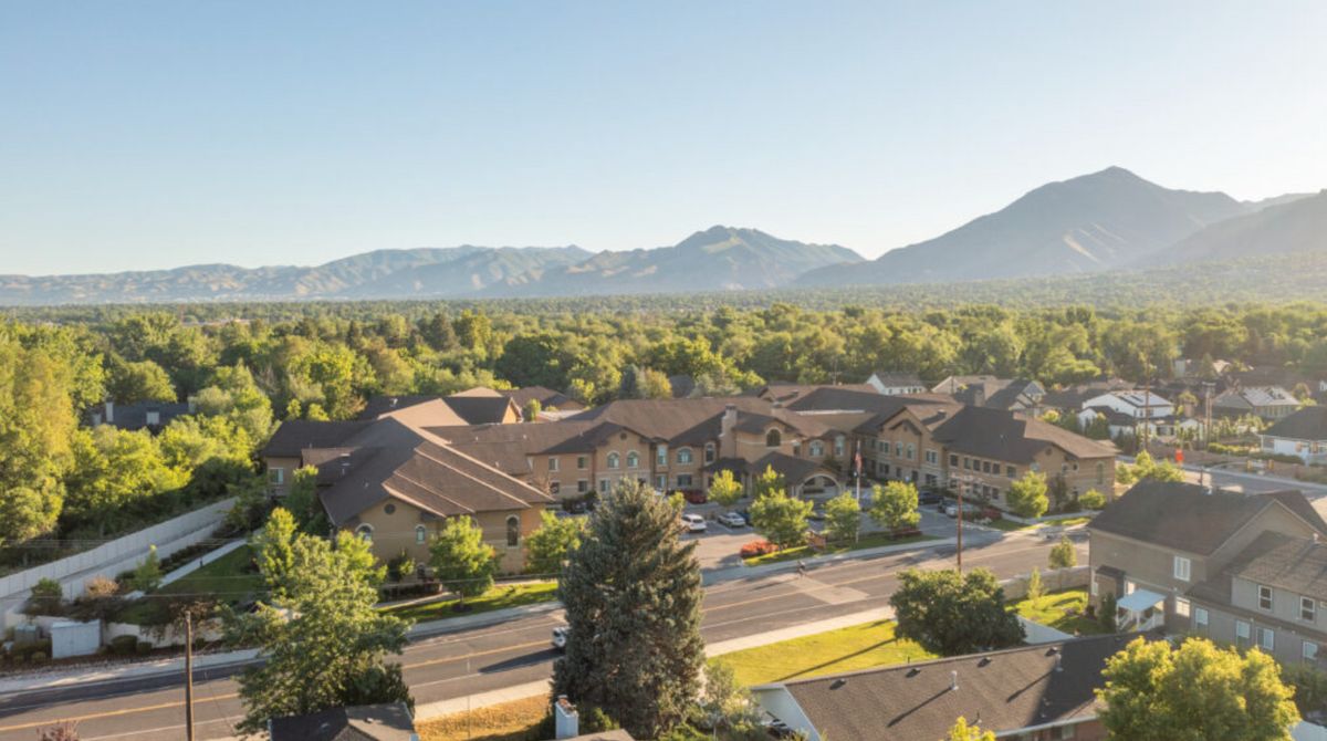 A scenic view of a residential area with mountains in the background on a sunny day.