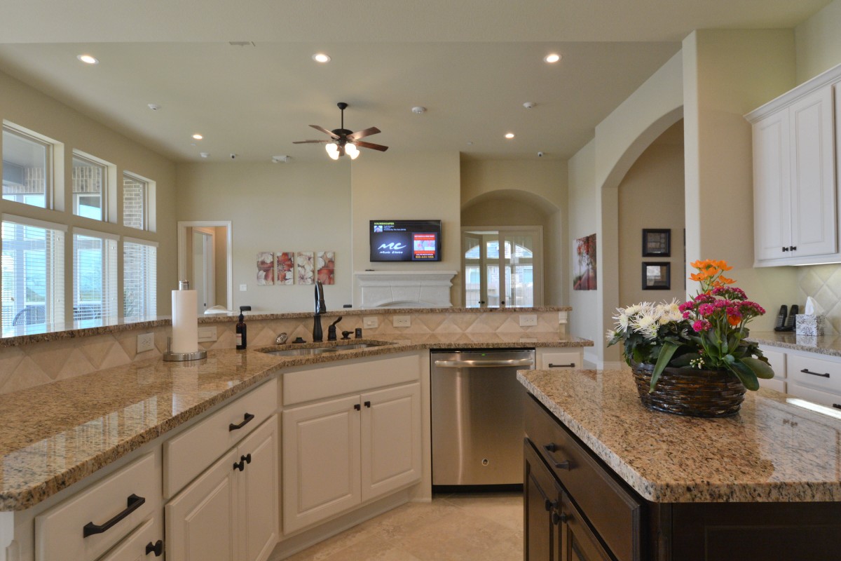A modern kitchen featuring granite countertops and stainless steel appliances in an open layout.
