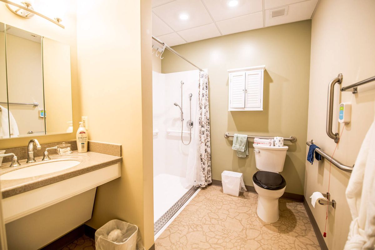 A clean and modern bathroom with a shower, toilet, and sink.