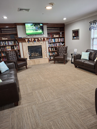 A cozy living room with comfortable seating, a fireplace, and shelves filled with books, perfect for relaxation.