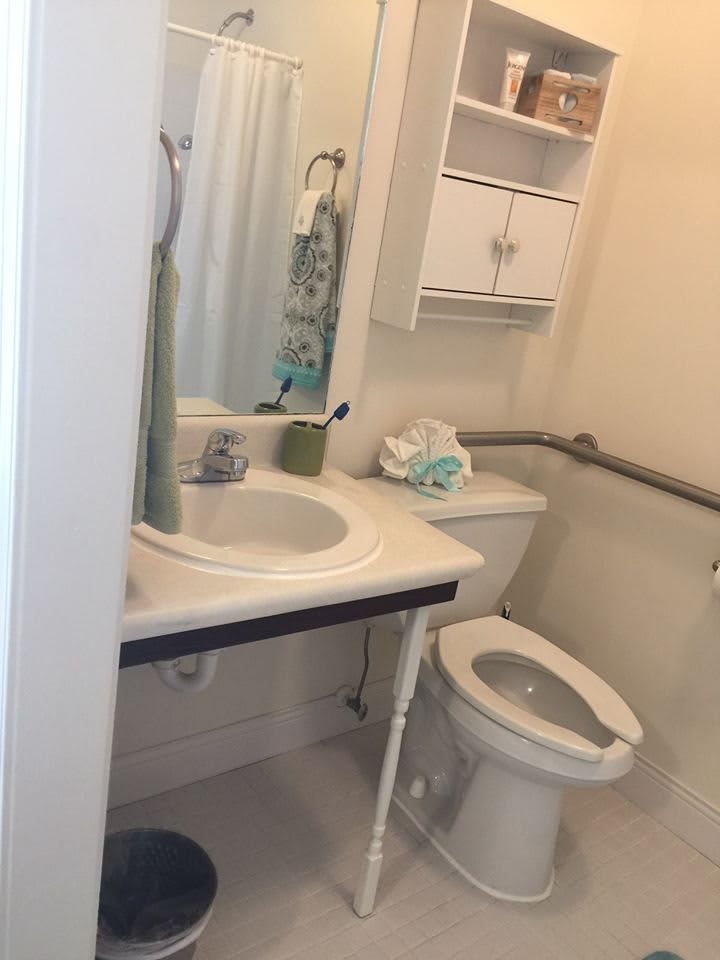 A small bathroom with a sink, toilet, and storage cabinet.