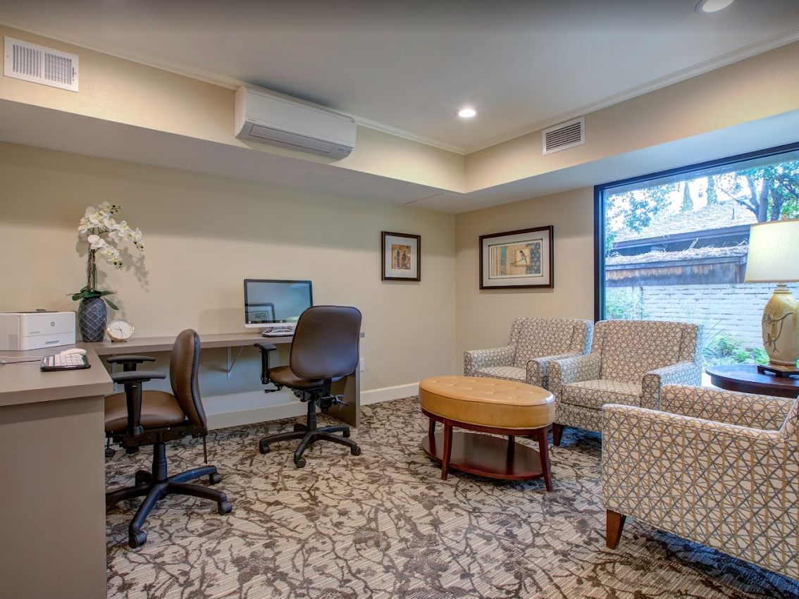 A cozy office space with a computer workstation and seating area.