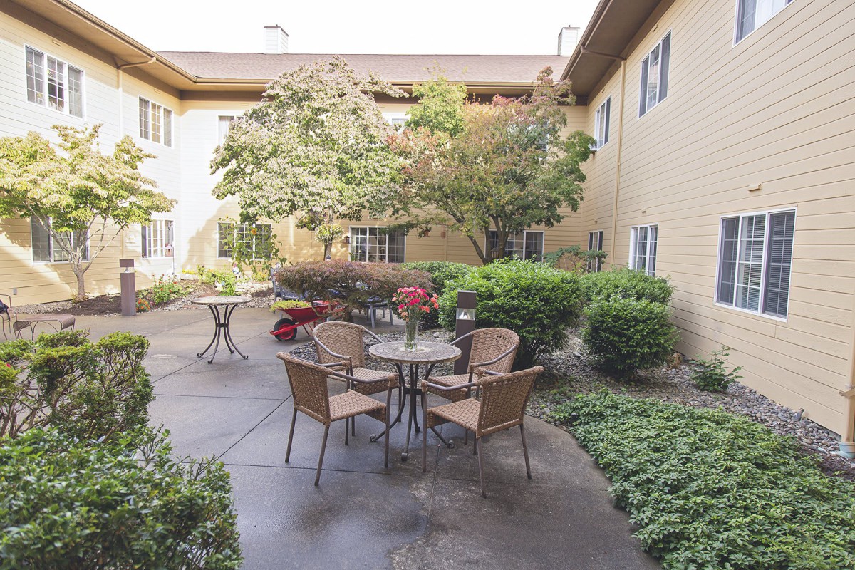 A tranquil courtyard with seating surrounded by lush greenery.