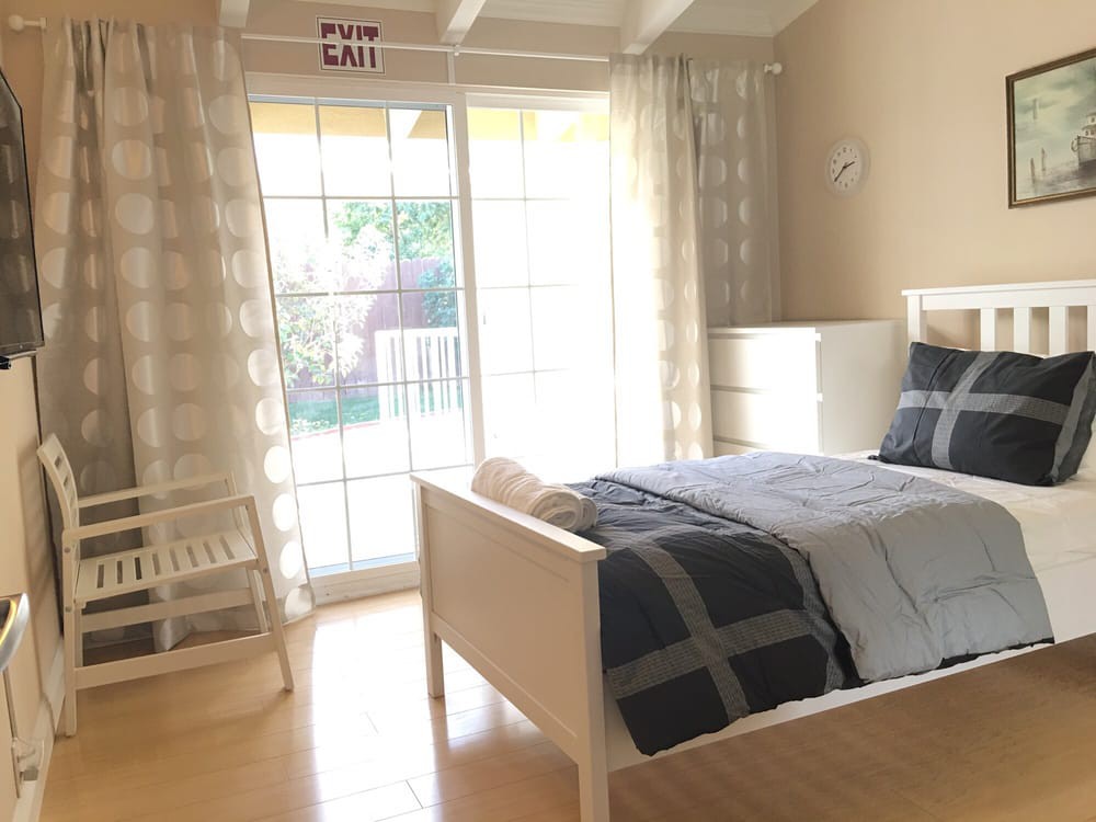 A bright and minimalist bedroom with a large window letting in natural light.
