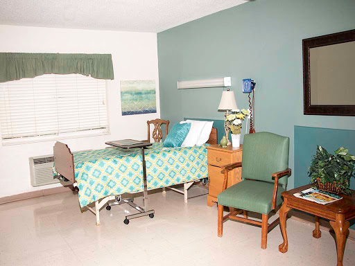 A well-organized patient room featuring a hospital bed, seating area, and decor that adds a comforting touch.