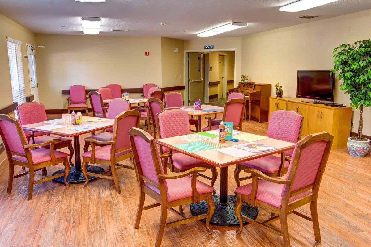 An empty dining room with tables and chairs arranged neatly.